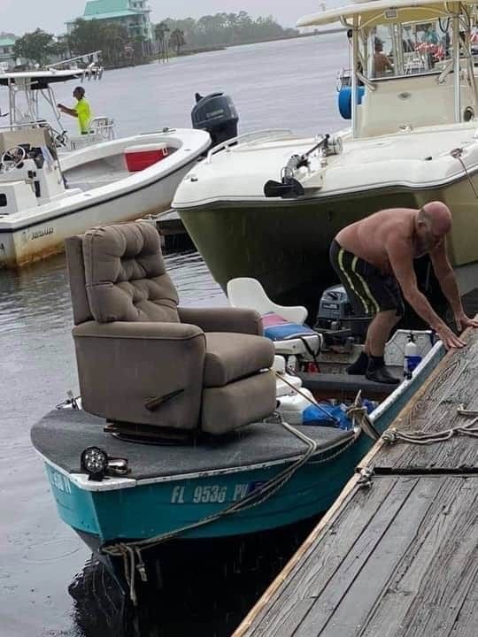 Man Stuffing a Sofa Into a Tiny Boat