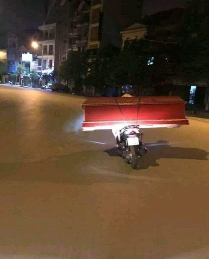 Guy on a Motorcycle Carrying a Coffin