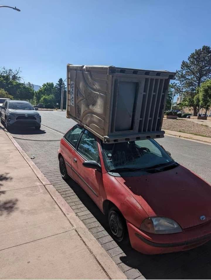 Car Carrying a Full Portable Toilet