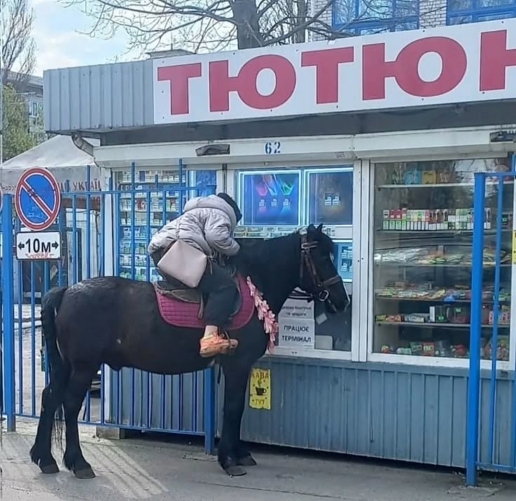 Woman on a Horse Approaching a Storefront