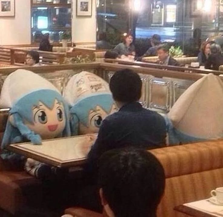 Person Eating With Three Giant Doll Companions