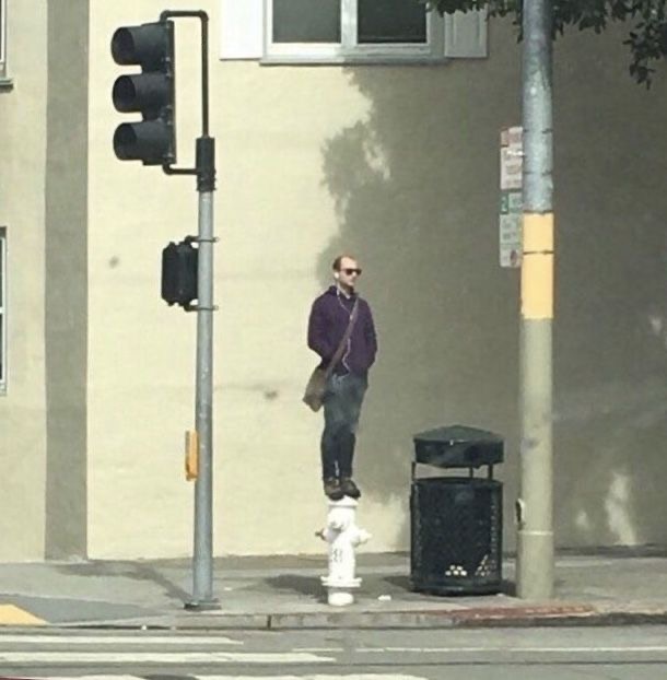 Man Standing on a Fire Hydrant