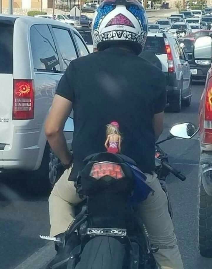Motorcyclist Riding With a Doll