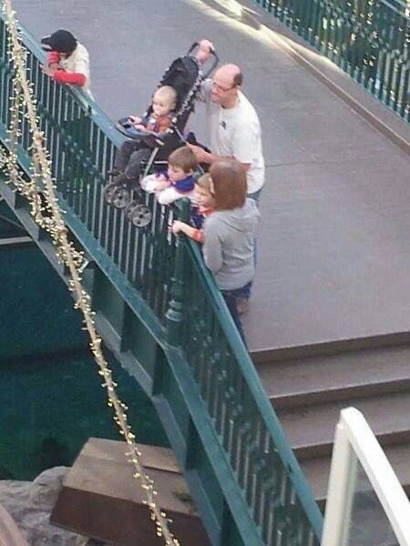 Man Balances Baby Stroller on a Railing 