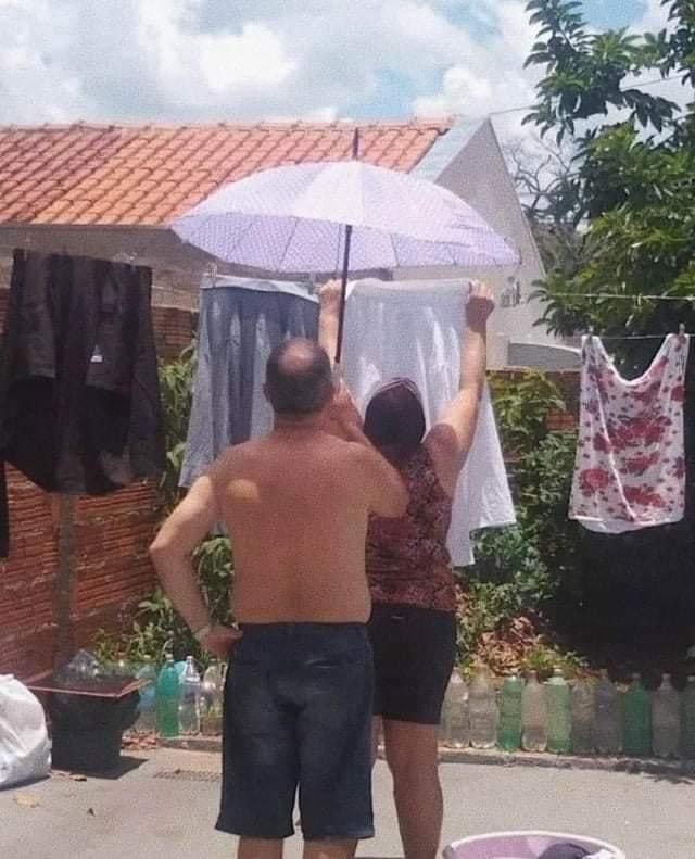 Man Holding an Umbrella Over His Wife