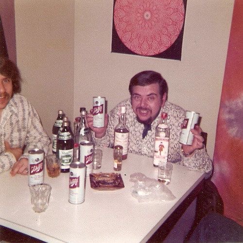 Man Drunk at a Table Covered in Beer Bottles
