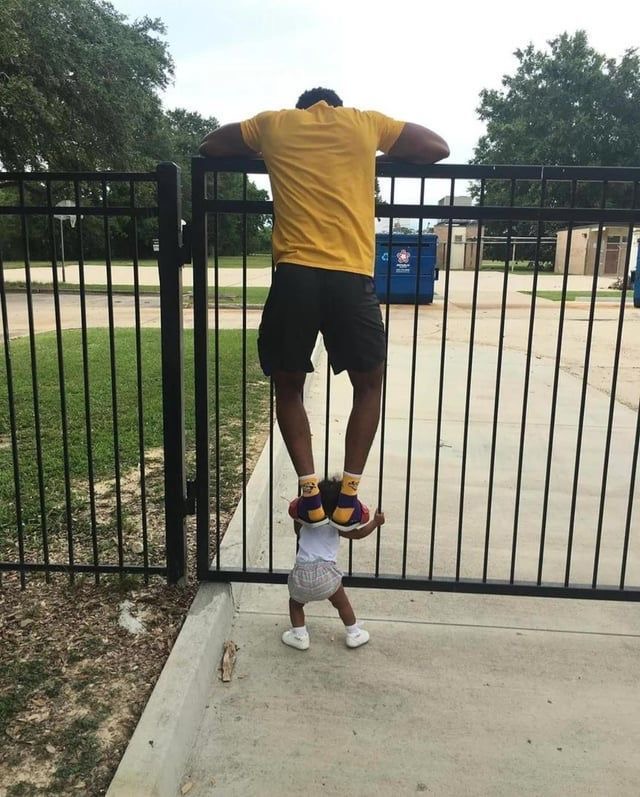 Dad Standing on His Baby to Climb a Fence