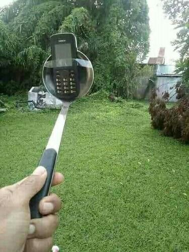 Person Tape-Attaches an Old Phone to a Spoon for a Selfie