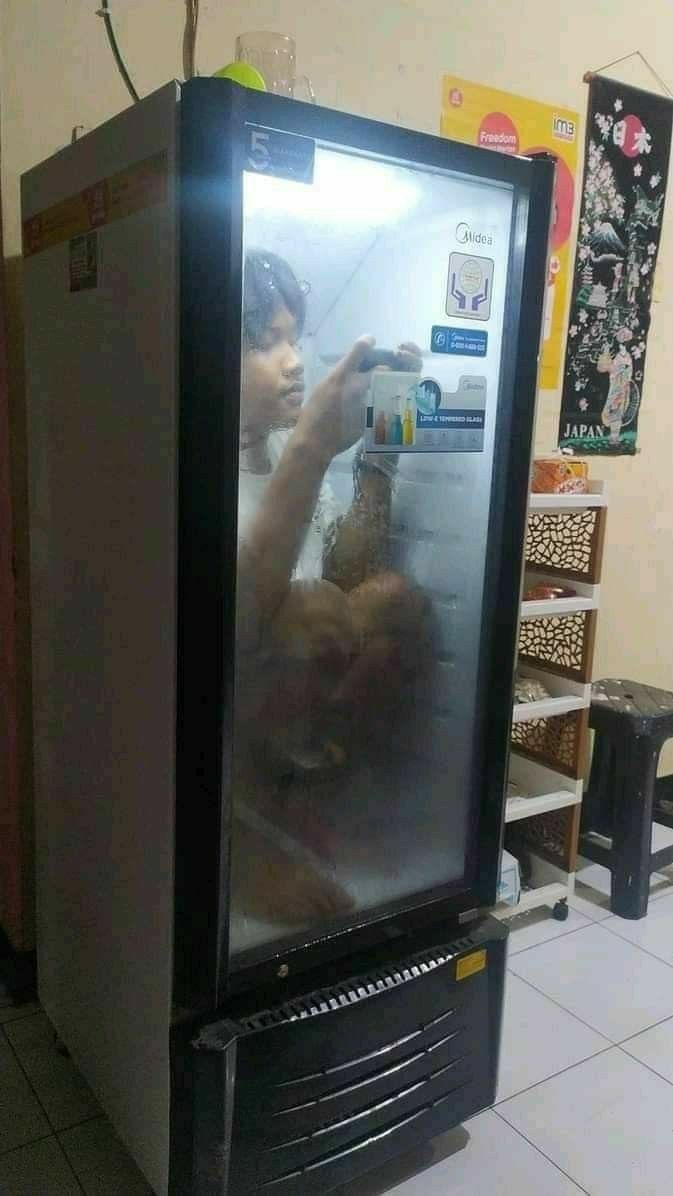 Kid Inside the Fridge Playing on His Phone