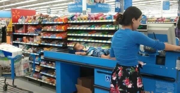 Mom Puts Her Kid on the Conveyor Belt at Checkout