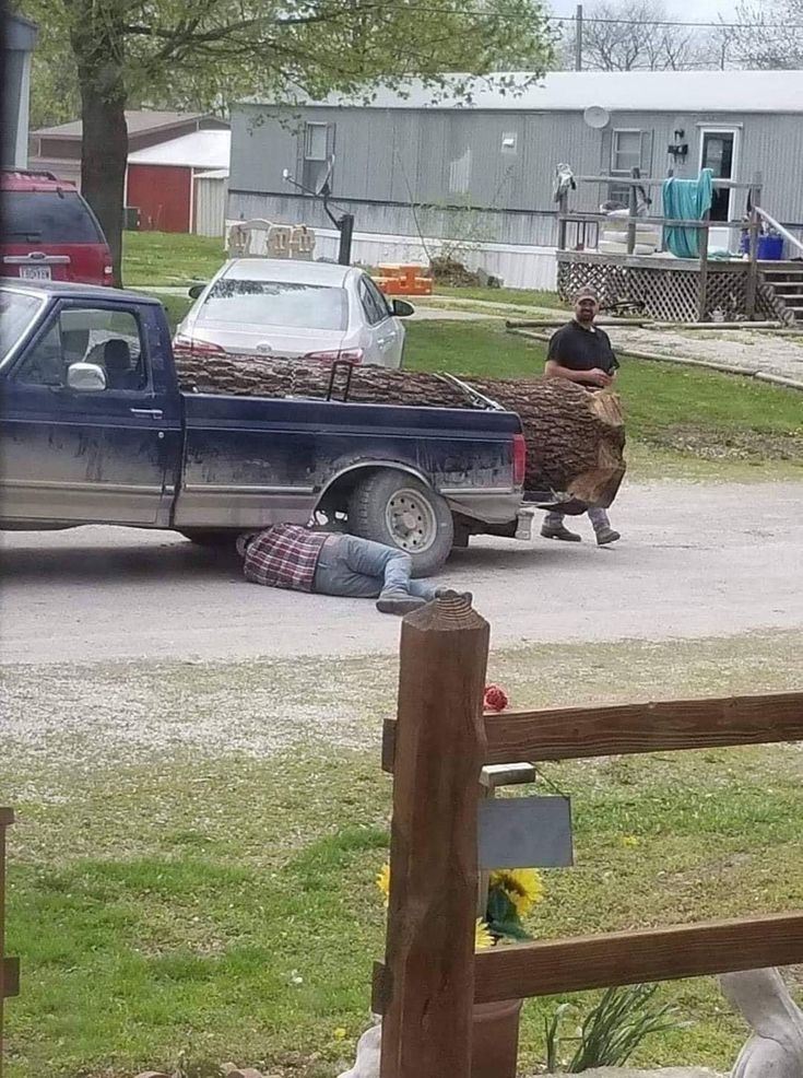 Man Under a Truck Loaded With a Giant Log