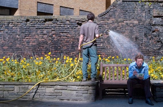 Guy Watering Plants Accidentally Spraying an Unaware Woman