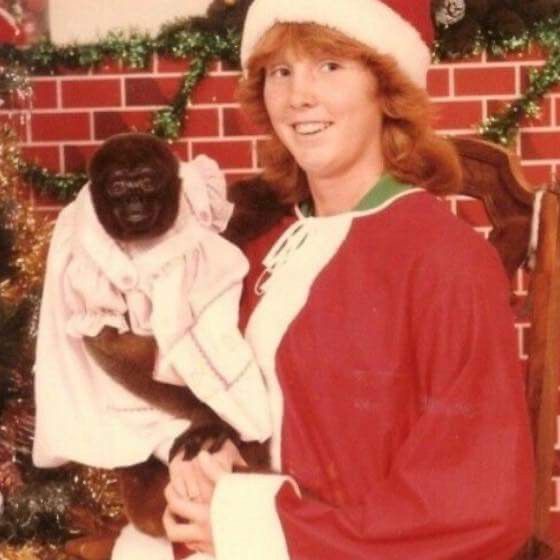 Girl Dressed as Santa Holding a Monkey