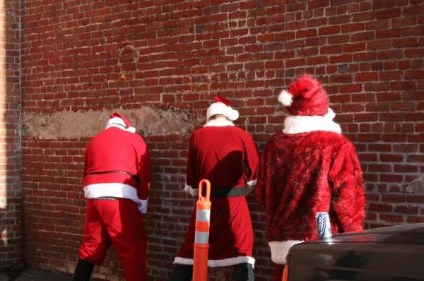 Santas Urinating Against a Wall