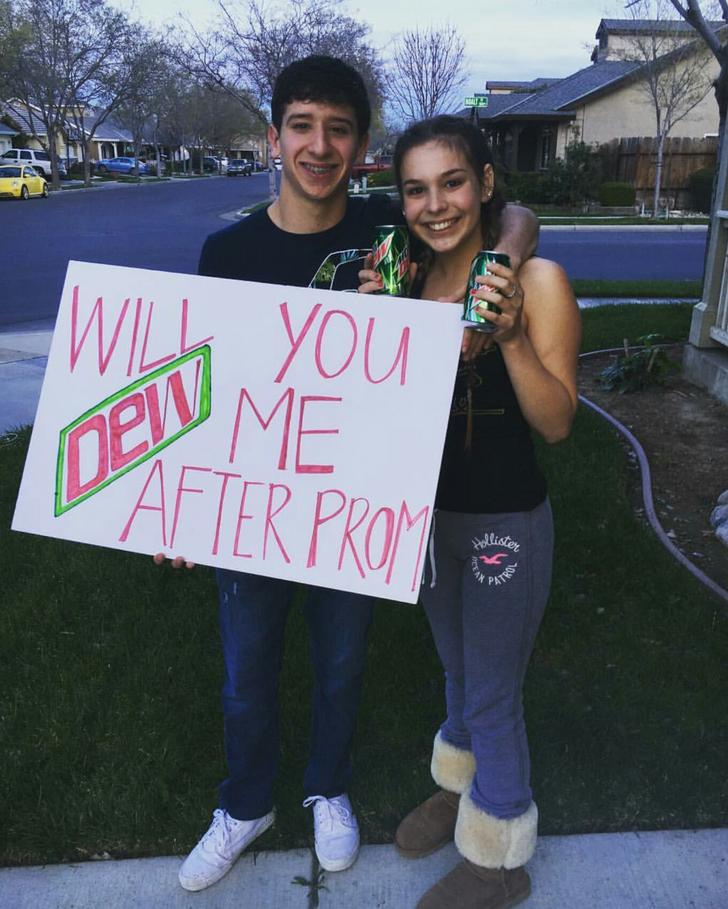 Prom pun on a white large paper and young couple posing with cans of Mountain Dew in a suburban sitting.