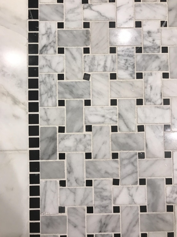Wall of tiles with on slightly diagonal tile that is clearly out of place.