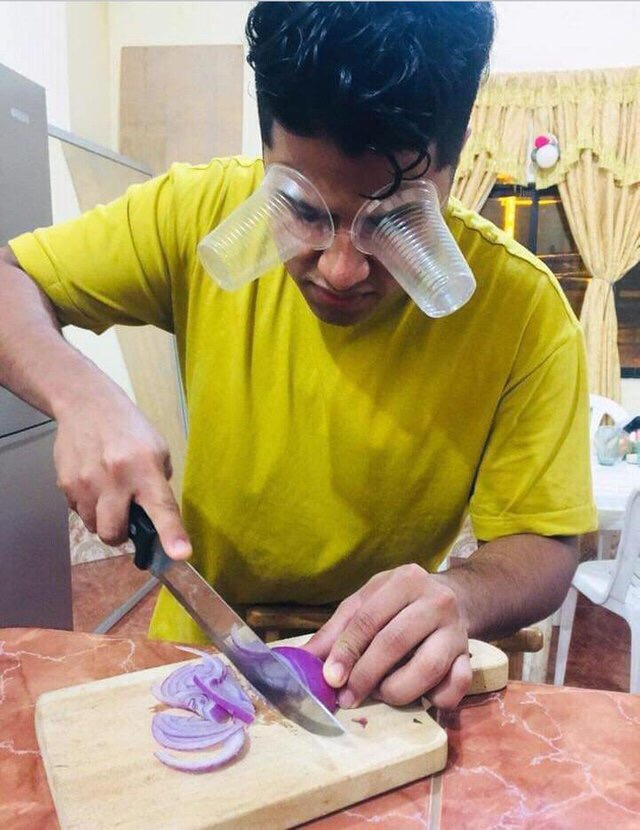 man cutting unions with cheap plastic cups on his eyes