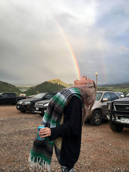 woman catching a rainbow into her mouth