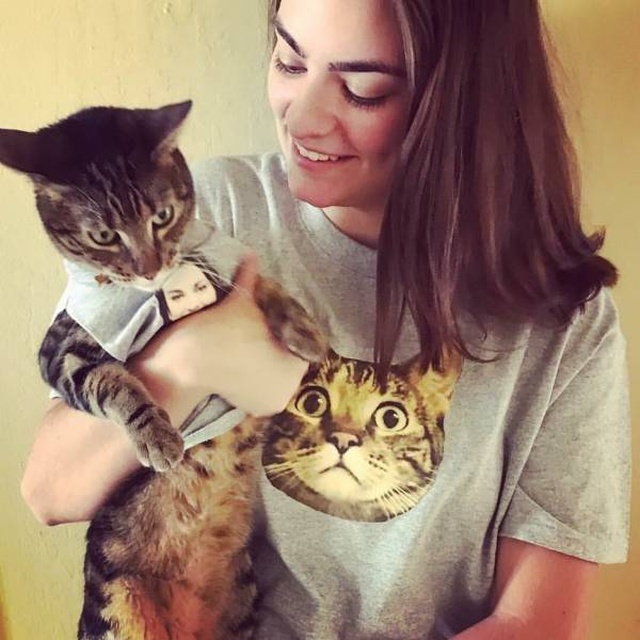 girl with a cat and a photo of that cat surprised on her shirt