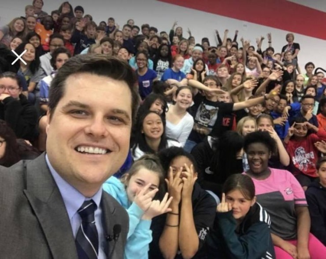 funny picture of Matt Gaetz taking a selfie with middle schoolers with one of them flipping him off