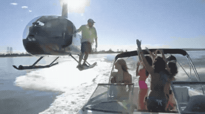 funny gif of a man getting off a helicopter into a yacht full of women