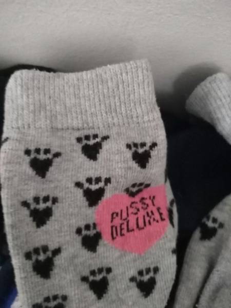 Silly socks that have footprints and the word 'pussy deluxe'