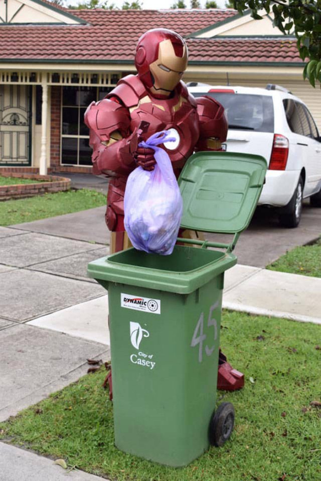 man dressed as iron man taking out the trash