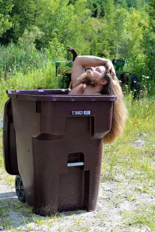 beautiful man lounging in a trashcan