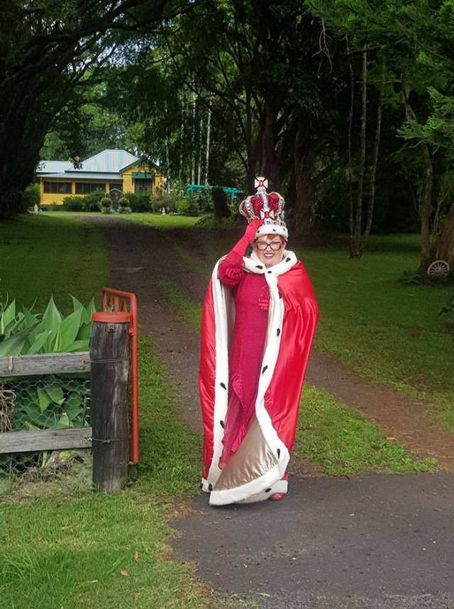 old woman dressed as a queen next to her trashcan