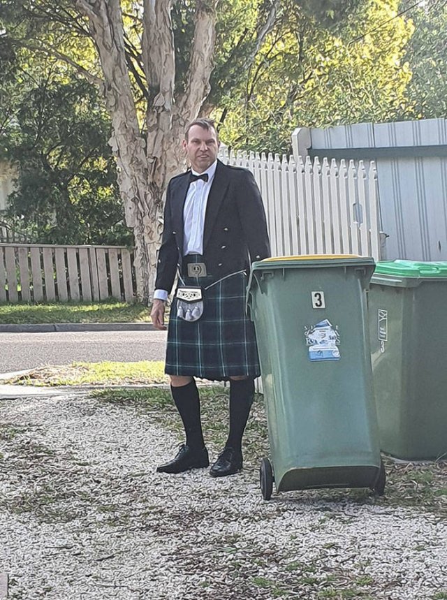 man wearing a kilt taking out the trash