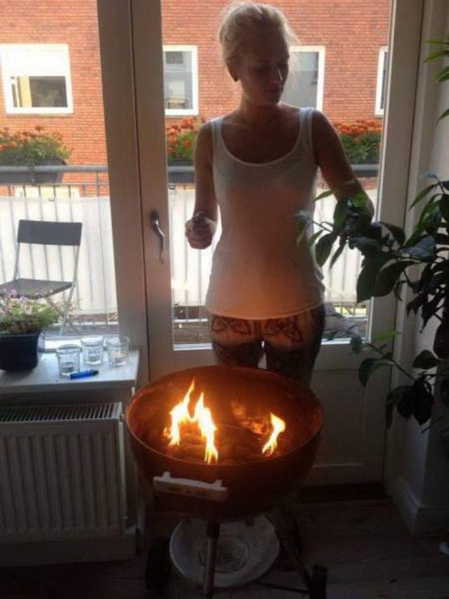 woman grilling indoors with burning flames charcoal grill fire