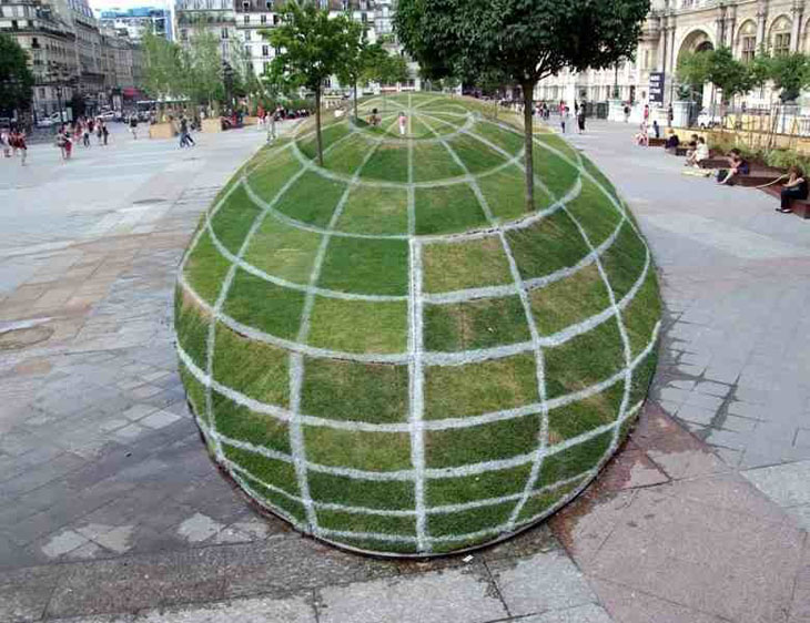 Optical illusion created on display outside Paris City Hall. Looks like a giant grass sphere, but it’s actually flat.