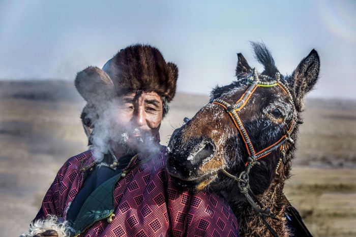 A Mongolian Horseman with his horse in the -40 cold of eastern Mongolia.