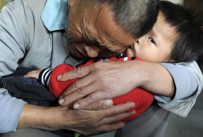 Wang Bangyin holds his rescued son. Wang’s son was among 60 children seeking parents after police freed them from human traffickers.