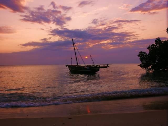Watch the sunset on a beach in Zanzibar, Africa.