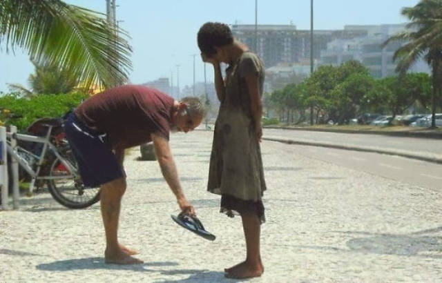 A man giving his shoes to a homeless girl in Rio De Janeiro.