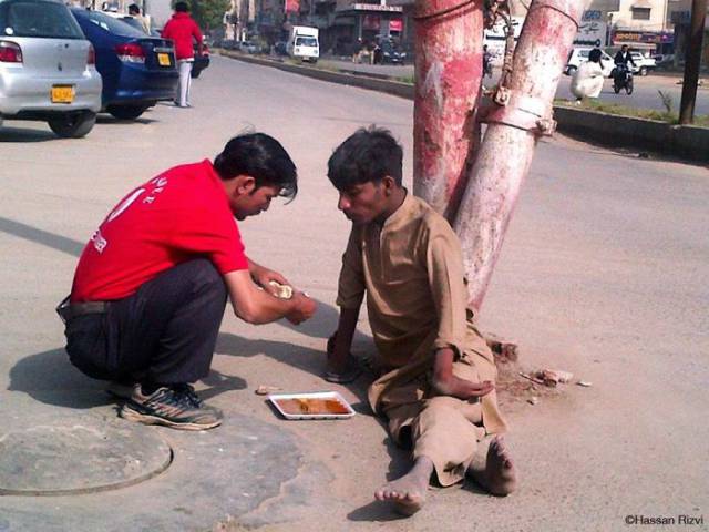 This Pakistani waiter feeds a homeless person who can't use his hands.