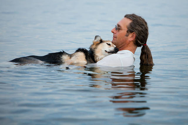 Every evening, this man takes his sick dog to the lake because the water helps his pain subside.