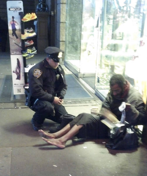 Officer giving shoes to a homeless man.