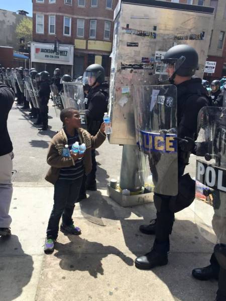 A boy giving water to the officers.
