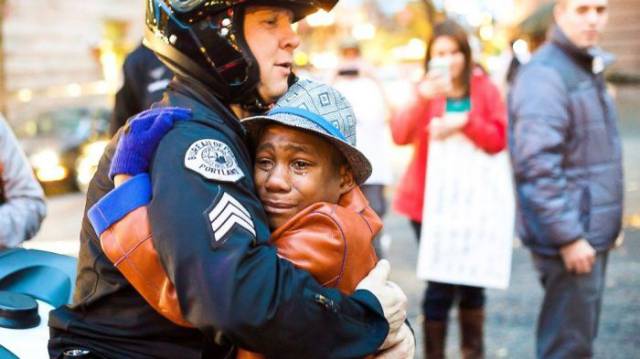 Officer and crying boy hugging.