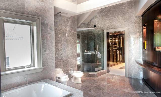 Here's another of its 25 bathrooms, featuring the requisite glass-door shower and walk-in closet.