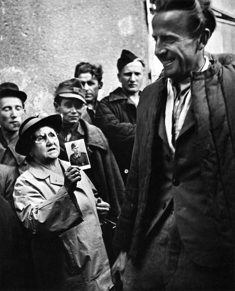 A Mother Shows A Picture Of Her Son To A Returning Prisoner Of War, 1947