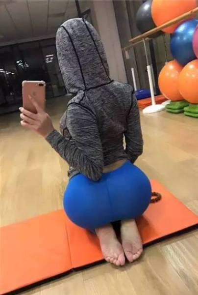 Selfie from behind of Gao Qian in a hoodie and blue leggings.