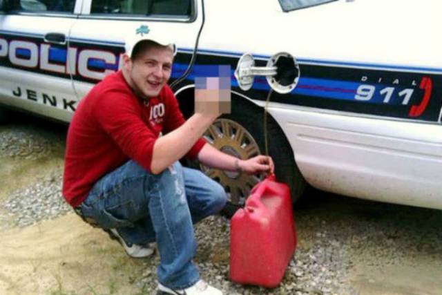 Siphoning Gas From A Police Car: It’s one thing to siphon gas from someone else’s car, but to siphon gas from a police car? Now you’re just asking for it. 22-year-old Michael Baker of Jenkins, Kentucky thought it would be a good idea to steal gas from a police car from the Jenkins Police Department and post a photo of himself performing the act on Facebook. And as an added touch, he flipped the bird. It didn’t take long for the photo to disperse among the roughly 2,000 citizens that make up Jenkins and for Baker to get caught by the police. He was charged with theft for unlawful tanking, and he spent the night in jail.
After Michael was released from the slammer, he took to Facebook to say, “yea lol i went too [sic] jail over facebook.”