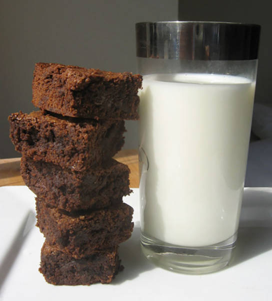 Picture of fresh brownies with a tall glass of milk