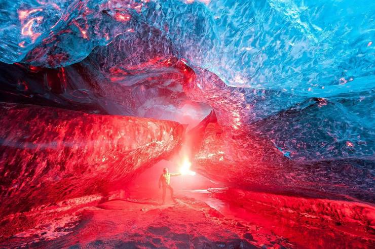 An Icelandic ice cave lit up by a burning flare.