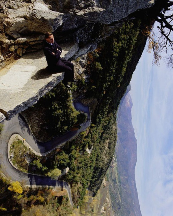funny optical illusions - guy sitting on edge of mountain