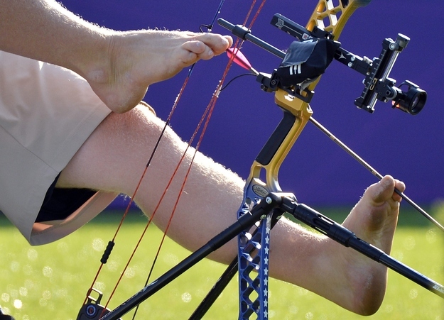 To compete he sits and supports the bow with one foot, while loading the arrow with the other.