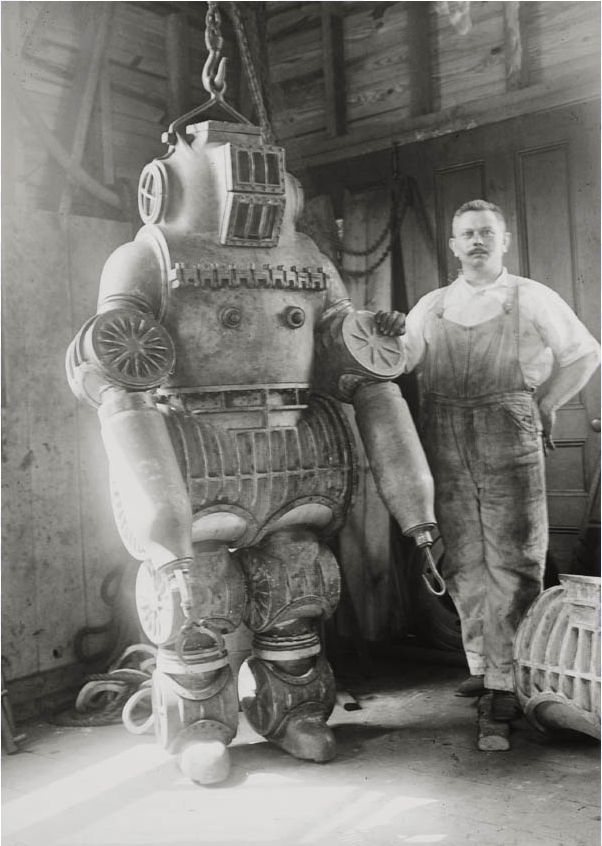 Chester E. Macduffee next to his newly patented, 250 kilo diving suit, 1911